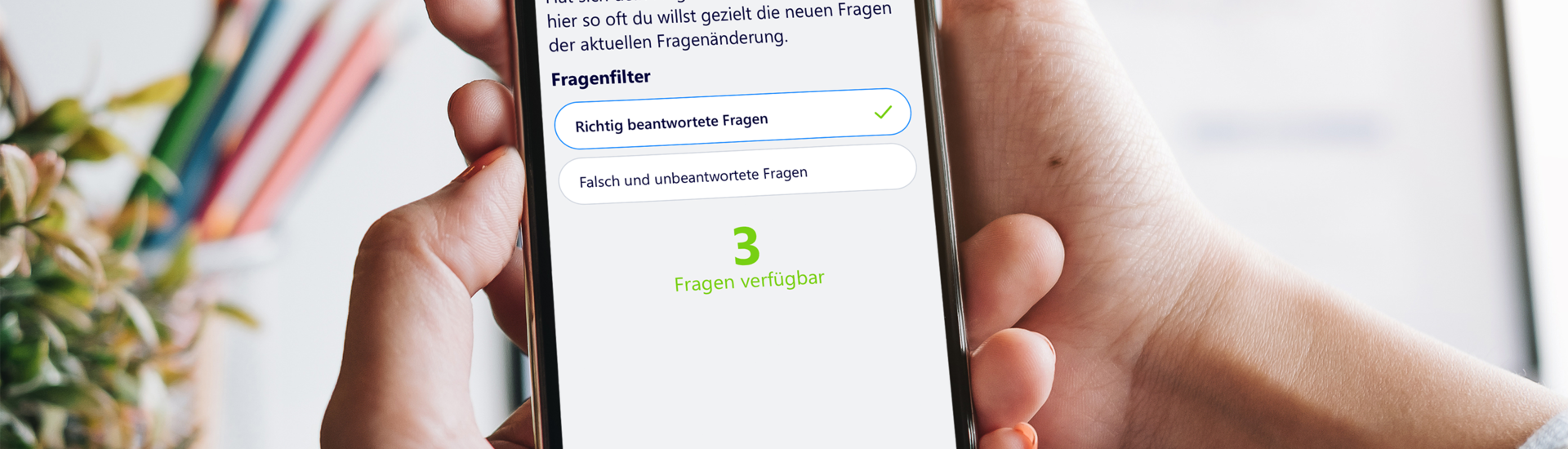 Smartphone mit Fahren Lernen Max Fragenänderung in der Hand vor Schreibtisch