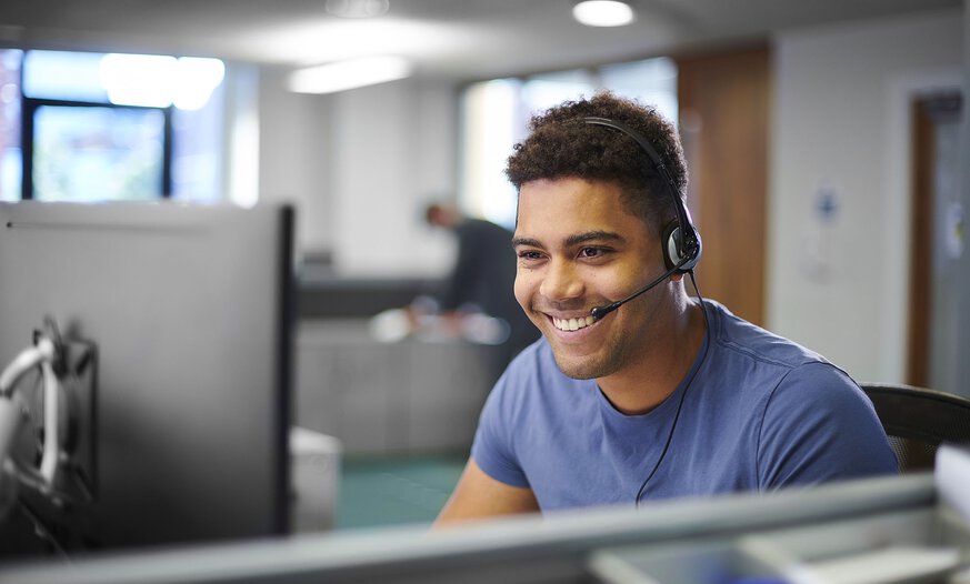 Junger Mann mit Headset in Büro