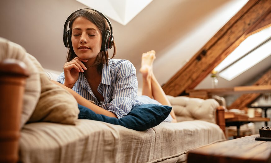 Junge Frau hört entspannt ein Audiotraining